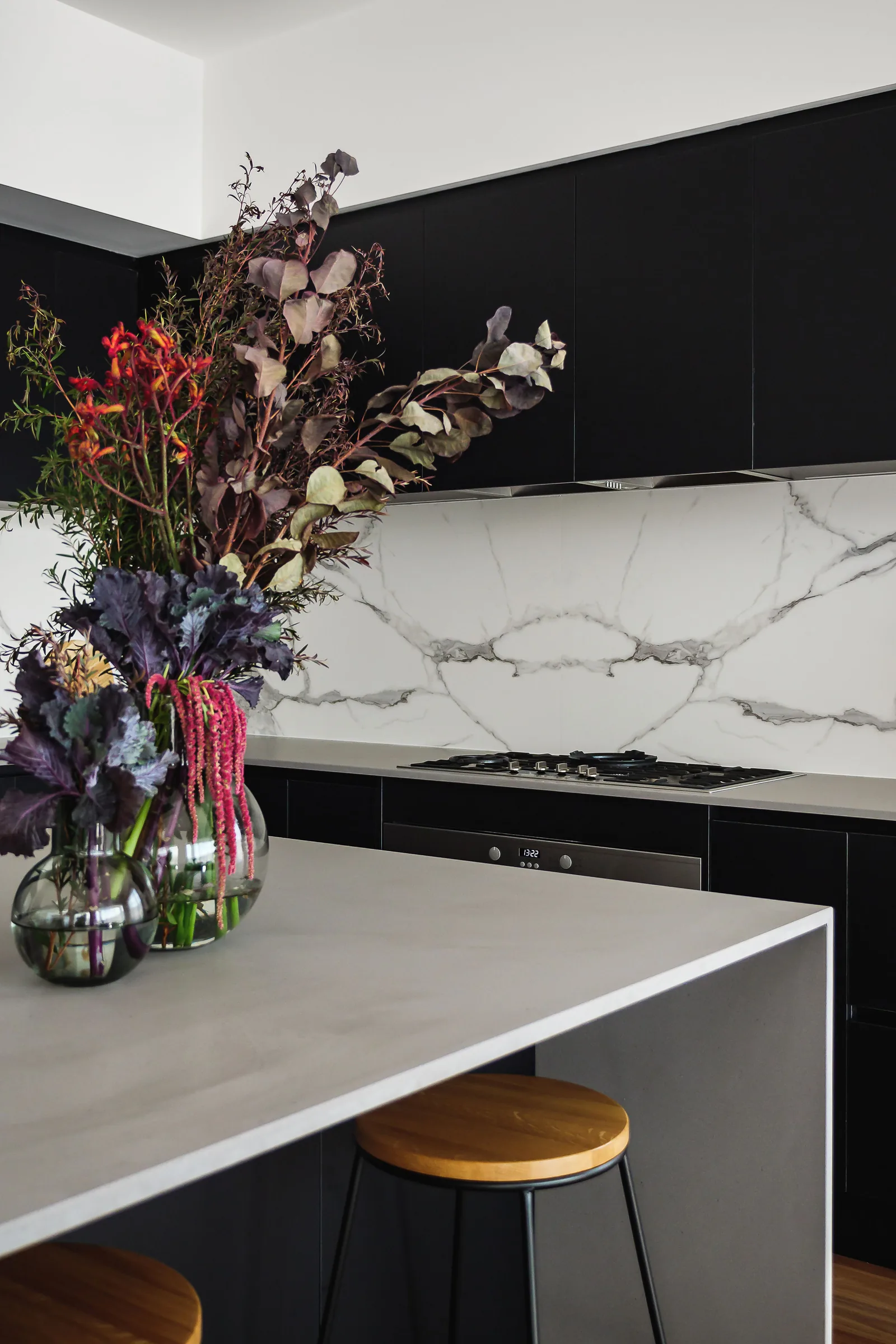 Grey-veined stone splashback framed by charcoal cabinetry