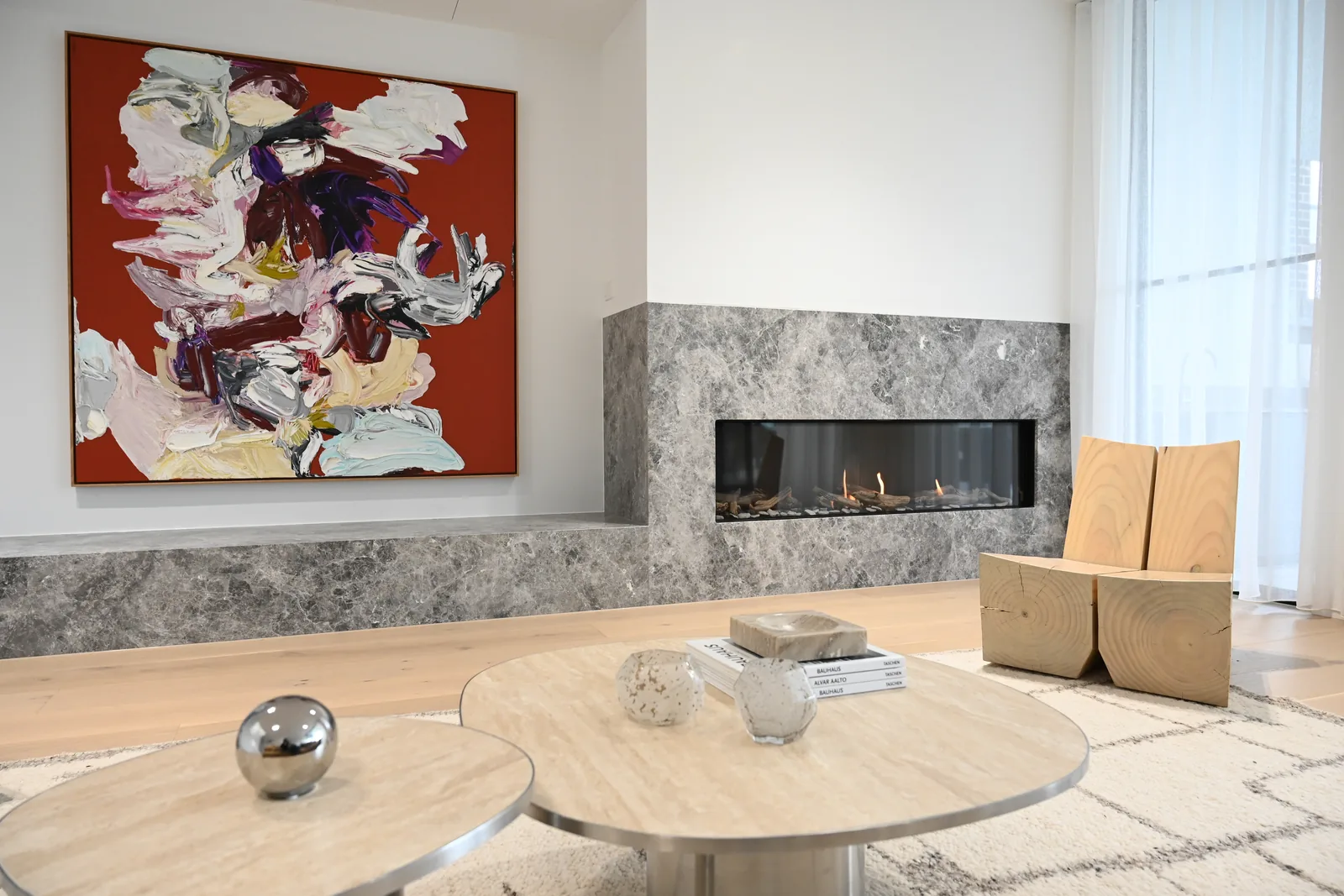 Noga Avenue living room with a grey marble fireplace, artwork and oak floors