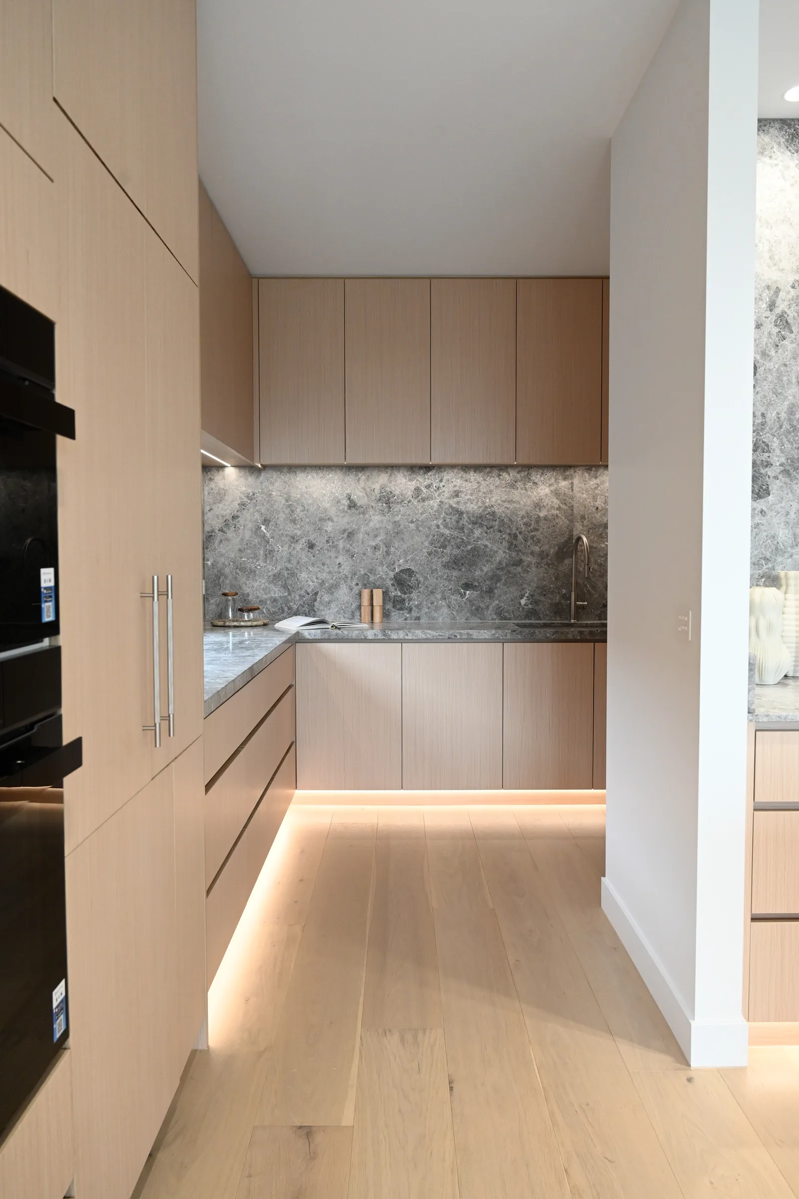 Light oak pantry cabinets and stone worktop with integrated lighting